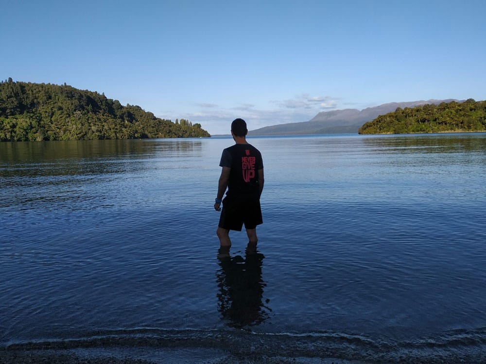 Experiencia Rafa chico moreno de espaldas en un lago y delante el cielo despejado